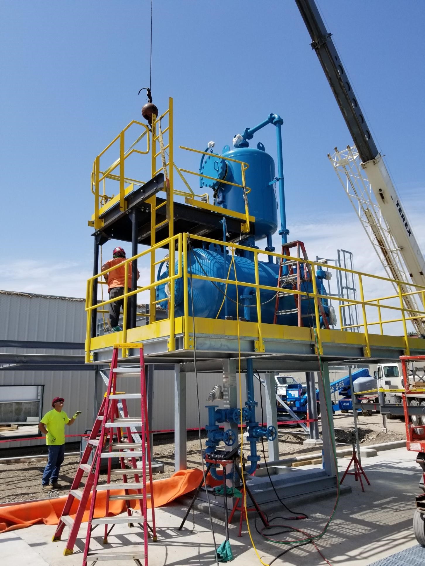 A crane lifting a boiler unit. NBW Inc.